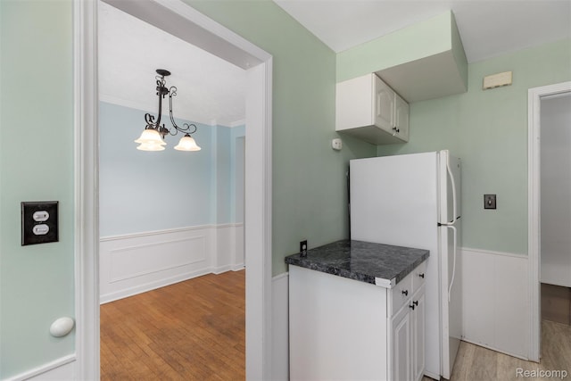 22953 Allen Rd, Saint Clair Shores, MI 48080 - kitchen with freestanding refrigerator, light wood-style floors, a wainscoted wall, white cabinets, and dark countertops