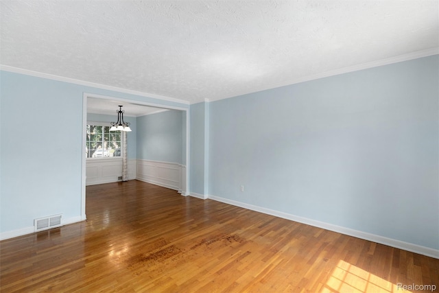 22953 Allen Rd, Saint Clair Shores, MI 48080 - spare room featuring a chandelier, wood finished floors, ornamental molding, and a textured ceiling