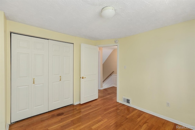 22953 Allen Rd, Saint Clair Shores, MI 48080 - unfurnished bedroom featuring light wood finished floors, a closet, and a textured ceiling