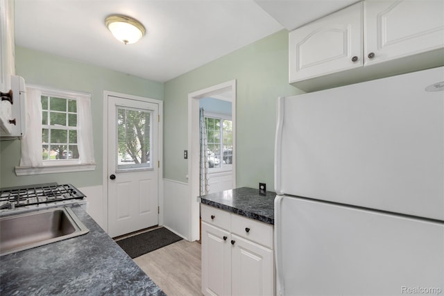 22953 Allen Rd, Saint Clair Shores, MI 48080 - kitchen featuring freestanding refrigerator, dark countertops, white cabinetry, and light wood finished floors