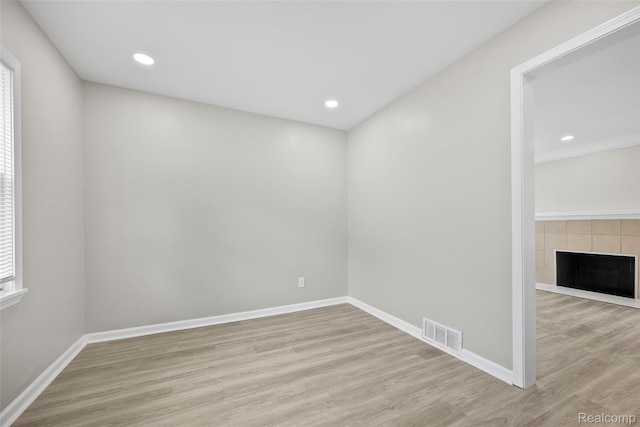 19215 Winthrop St, Dearborn, MI 48235 - unfurnished room featuring wood finished floors, baseboards, a tile fireplace, recessed lighting, and plenty of natural light