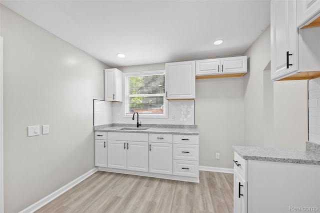 19215 Winthrop St, Dearborn, MI 48235 - kitchen featuring a sink, light wood-style floors, backsplash, white cabinetry, and recessed lighting