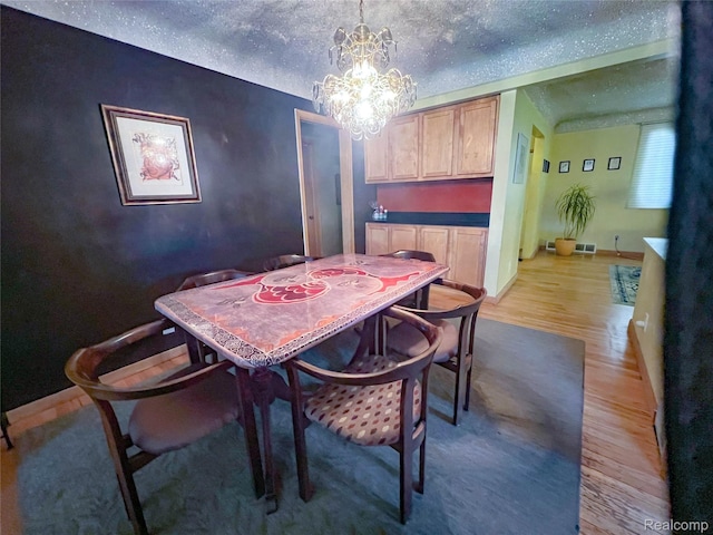 21710 Parklawn St, Oak Park, MI 48237 - dining room featuring light wood-type flooring, a chandelier, and a textured ceiling