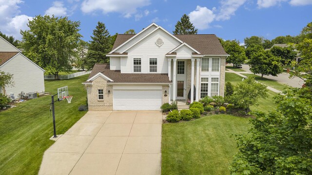 6533 Cannon Farms Dr NE, Rockford, MI 49341 - greek revival inspired property with brick siding, a garage, concrete driveway, and a front lawn