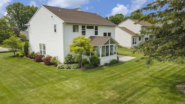 6533 Cannon Farms Dr NE, Rockford, MI 49341 - back of property with a sunroom, a lawn, and roof with shingles