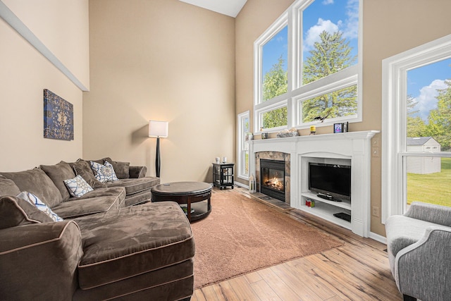 6533 Cannon Farms Dr NE, Rockford, MI 49341 - living area with hardwood / wood-style floors, a high ceiling, a glass covered fireplace, and baseboards