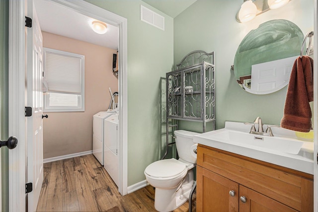 6533 Cannon Farms Dr NE, Rockford, MI 49341 - bathroom featuring washer and dryer, toilet, wood finished floors, vanity, and baseboards
