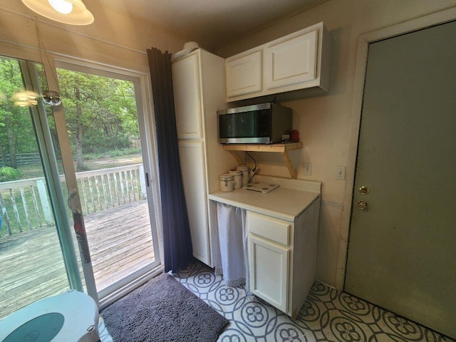 661 W Michigan Rd, Twin Lake, MI 49457 - kitchen featuring stainless steel microwave, light countertops, and white cabinets