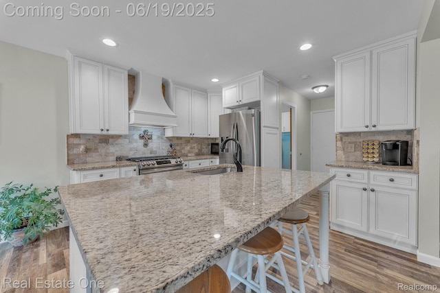 15719 Greenview, Fraser, MI 48026 - kitchen featuring custom exhaust hood, appliances with stainless steel finishes, light wood-type flooring, white cabinets, and tasteful backsplash
