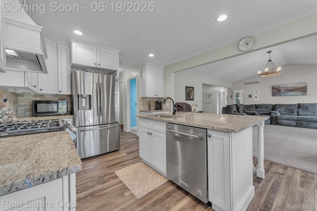 15719 Greenview, Fraser, MI 48026 - kitchen with stainless steel appliances, white cabinetry, ventilation hood, light wood-style flooring, and vaulted ceiling