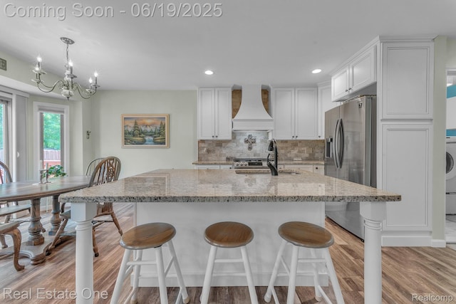 15719 Greenview, Fraser, MI 48026 - kitchen featuring premium range hood, stainless steel fridge with ice dispenser, white cabinets, a breakfast bar, and recessed lighting