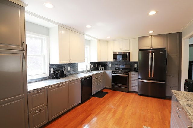 2524 N Mckinley Rd, Flushing, MI 48433 - kitchen with appliances with stainless steel finishes, a sink, decorative backsplash, light wood-type flooring, and light stone countertops