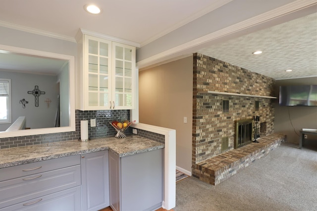 2524 N Mckinley Rd, Flushing, MI 48433 - kitchen with tasteful backsplash, glass insert cabinets, crown molding, a fireplace, and light colored carpet