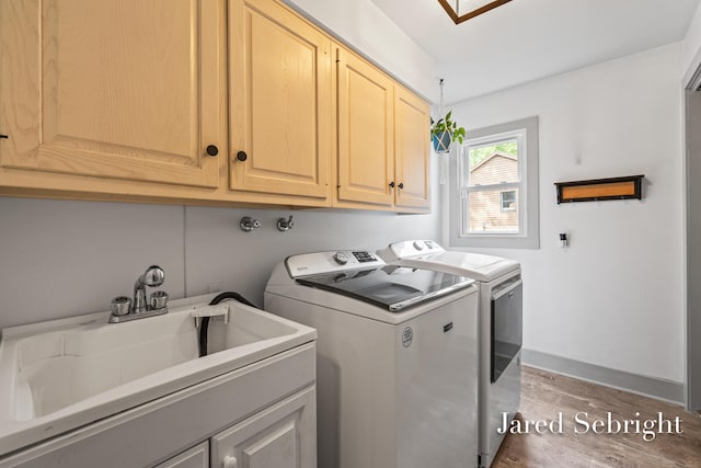 6872 Forest Valley Dr SE, Grand Rapids, MI 49546 - washroom with separate washer and dryer, cabinet space, and light wood-type flooring