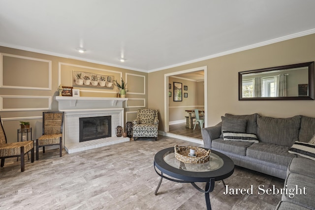 6872 Forest Valley Dr SE, Grand Rapids, MI 49546 - living room featuring crown molding, wood finished floors, a brick fireplace, and baseboards