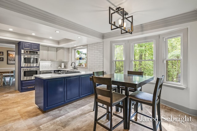 6872 Forest Valley Dr SE, Grand Rapids, MI 49546 - kitchen with blue cabinetry, appliances with stainless steel finishes, ornamental molding, decorative backsplash, and a peninsula