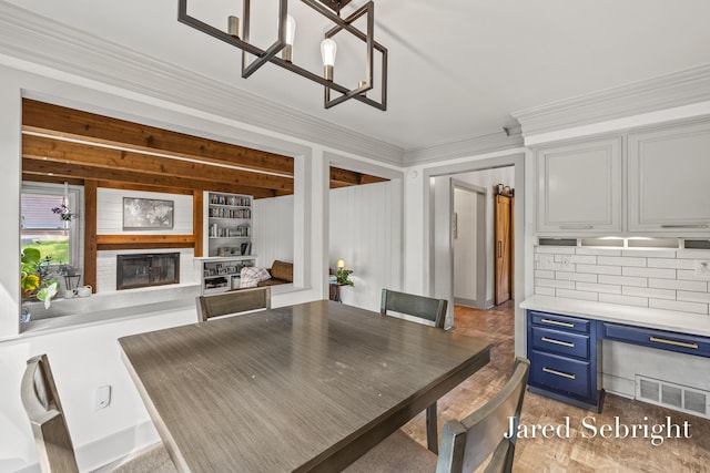 6872 Forest Valley Dr SE, Grand Rapids, MI 49546 - dining area with a glass covered fireplace, crown molding, and a chandelier