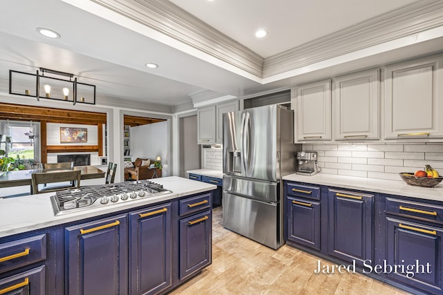 6872 Forest Valley Dr SE, Grand Rapids, MI 49546 - kitchen with stainless steel appliances, ornamental molding, blue cabinets, light wood-style floors, and backsplash