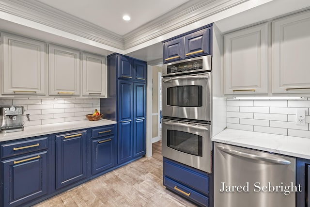 6872 Forest Valley Dr SE, Grand Rapids, MI 49546 - kitchen featuring appliances with stainless steel finishes, blue cabinetry, light wood finished floors, white cabinetry, and crown molding