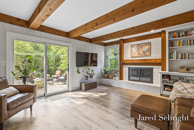 6872 Forest Valley Dr SE, Grand Rapids, MI 49546 - living room featuring wood finished floors, a brick fireplace, beamed ceiling, and wood walls
