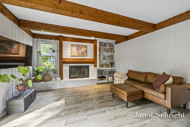 6872 Forest Valley Dr SE, Grand Rapids, MI 49546 - living room with a brick fireplace, wood finished floors, beamed ceiling, and wooden walls