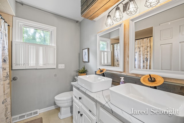 6872 Forest Valley Dr SE, Grand Rapids, MI 49546 - full bath with healthy amount of natural light, double vanity, toilet, and tile patterned flooring
