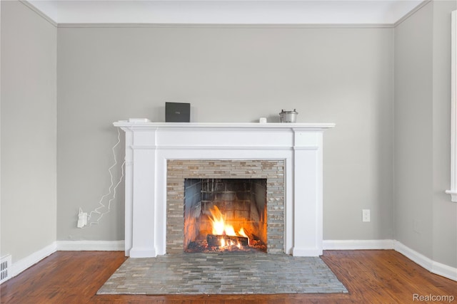 3951 Devonshire Rd, Detroit, MI 48224 - detailed view of wood finished floors, a warm lit fireplace, and baseboards