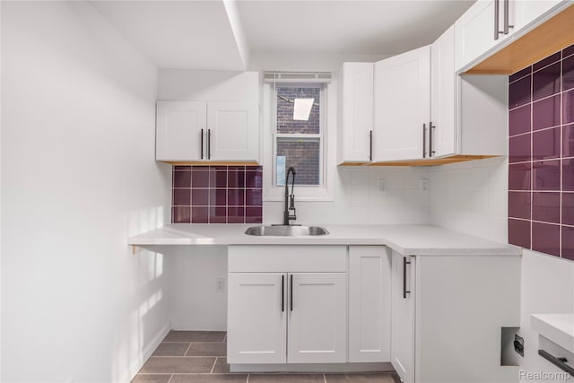 3951 Devonshire Rd, Detroit, MI 48224 - kitchen featuring a sink, light countertops, decorative backsplash, and white cabinetry