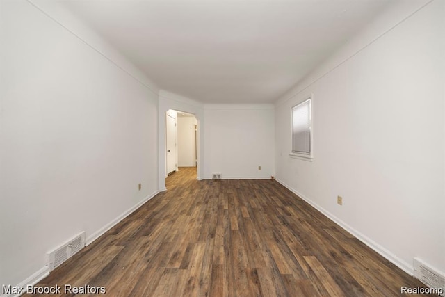 17187 Vaughan St, Detroit, MI 48219 - unfurnished room with dark wood finished floors, arched walkways, and baseboards