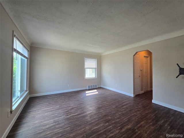 29263 Barton St, Garden City, MI 48135 - spare room with a textured ceiling, dark wood-type flooring, and arched walkways