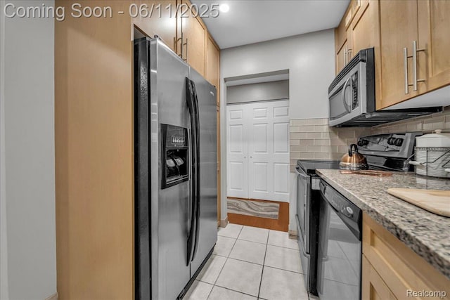 1001 W Jefferson Ave Unit 2I, Detroit, MI 48226 - kitchen with stainless steel appliances, tasteful backsplash, light tile patterned flooring, and light stone countertops
