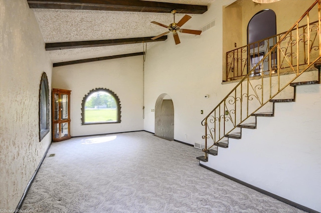 5379 N Irish Rd, Davison, MI 48423 - unfurnished living room featuring carpet floors, ceiling fan, arched walkways, beamed ceiling, and stairway