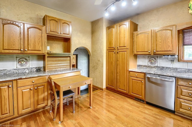 5379 N Irish Rd, Davison, MI 48423 - kitchen featuring stainless steel dishwasher, a textured wall, light wood finished floors, arched walkways, and stone counters