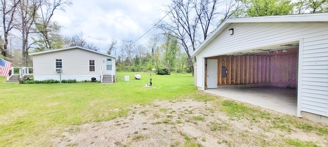 8326 S Delaware Ave, Baldwin, MI 49304 - view of grassy yard featuring a garage, driveway, an outdoor structure, and entry steps