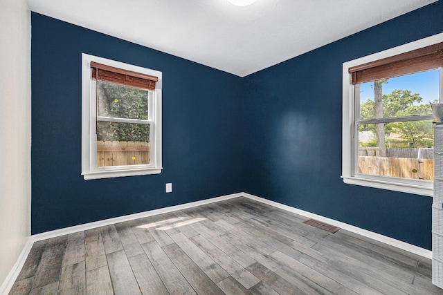 123 Oneida St SW, Wyoming, MI 49548 - spare room with plenty of natural light, wood finished floors, and baseboards