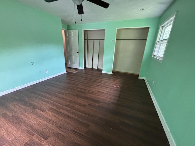 1965 E Kimmel Rd, Jackson, MI 49201 - unfurnished bedroom with dark wood-style flooring, two closets, baseboards, and a ceiling fan
