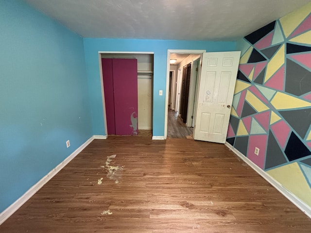 1965 E Kimmel Rd, Jackson, MI 49201 - unfurnished bedroom with wood finished floors, baseboards, and a closet