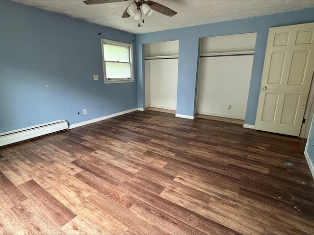 1965 E Kimmel Rd, Jackson, MI 49201 - unfurnished bedroom with two closets, wood finished floors, baseboard heating, baseboards, and a textured ceiling