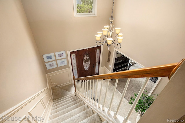 47951 Picadilly Ct, Canton, MI 48187 - stairway with a chandelier, a decorative wall, and a high ceiling