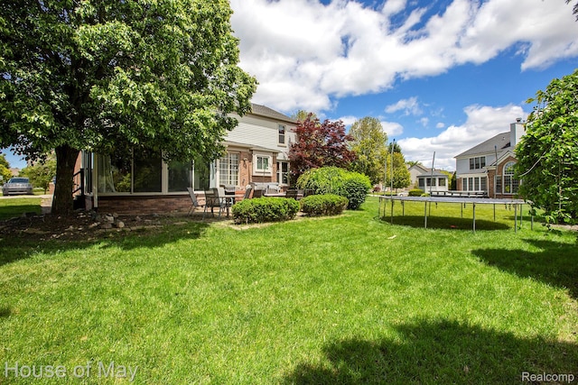 47951 Picadilly Ct, Canton, MI 48187 - view of green lawn featuring a trampoline, a patio, and an outdoor living space