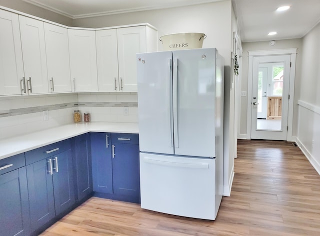 121 S Marshall St, New Buffalo, MI 49117 - kitchen featuring freestanding refrigerator, blue cabinets, light countertops, light wood-type flooring, and ornamental molding