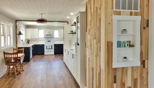 121 S Marshall St, New Buffalo, MI 49117 - kitchen with white appliances, a sink, light countertops, light wood-style floors, and white cabinetry