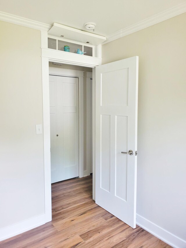 121 S Marshall St, New Buffalo, MI 49117 - unfurnished bedroom featuring crown molding, light wood-type flooring, and baseboards