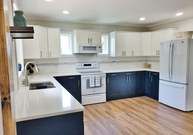 121 S Marshall St, New Buffalo, MI 49117 - kitchen with white appliances, a sink, blue cabinetry, crown molding, and decorative backsplash