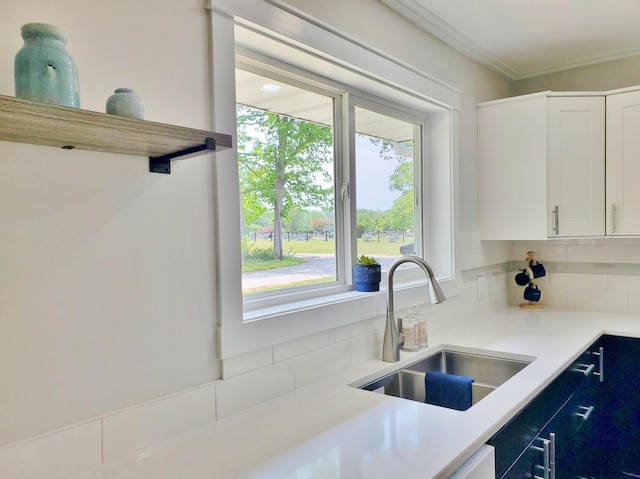 121 S Marshall St, New Buffalo, MI 49117 - kitchen with a sink, decorative backsplash, white cabinets, light countertops, and crown molding