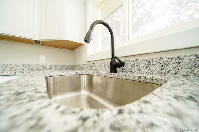 16282 Evergreen Ave, Eastpointe, MI 48021 - kitchen view of a sink, white cabinets, and light stone countertops