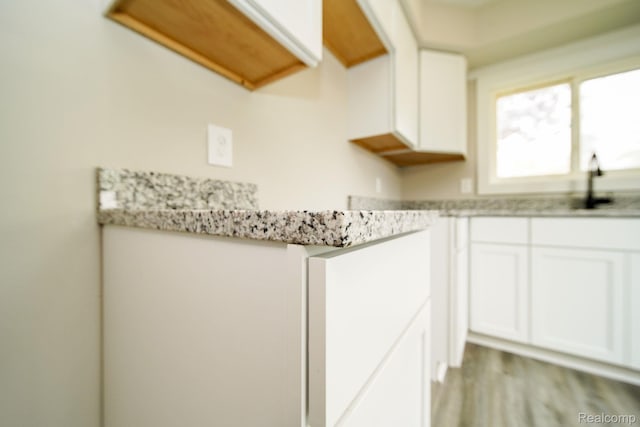 16282 Evergreen Ave, Eastpointe, MI 48021 - kitchen featuring white cabinets, a sink, light wood finished floors, and light stone counters