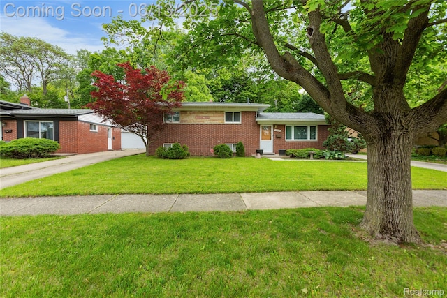 32702 Winona St, Westland, MI 48185 - split level home with brick siding, a front yard, driveway, and a garage