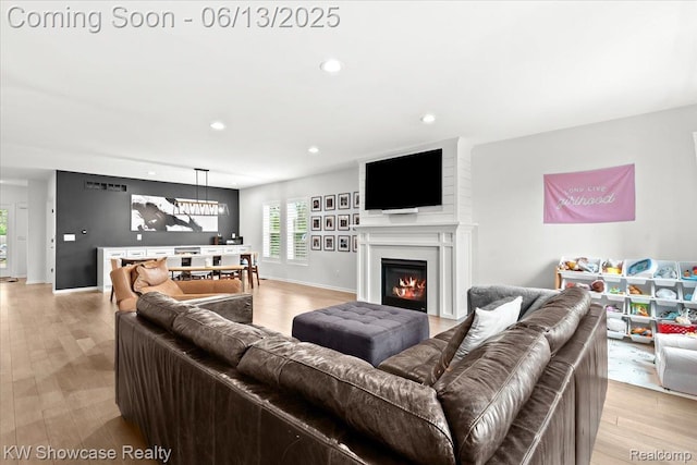 3278 Tyler Ave, Berkley, MI 48072 - living room featuring light wood-type flooring, a chandelier, recessed lighting, and a warm lit fireplace