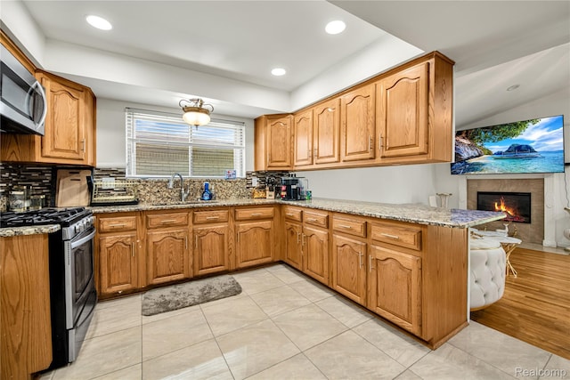 37288 Vernon Dr, Sterling Heights, MI 48310 - kitchen with stainless steel appliances, a sink, tasteful backsplash, light stone countertops, and a peninsula